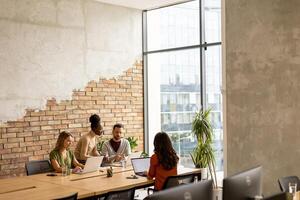 Young multiethnic startup team working in the rustic office photo