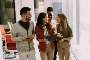 Young multiethnic startup team walking in the modern office photo