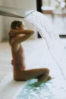 Young woman relaxing by the indoor swimming pool photo