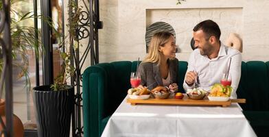 Young couple having lunch and drinking fresh squeezed juice in the restaurant photo