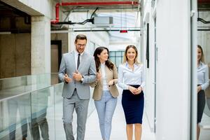 Young startup team have a discussion while walking in the modern office corridor photo