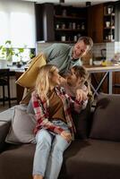 Playful family pillow fight in a cozy living room at dusk photo