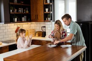 alegre familia disfrutando hecho en casa chocolate pastel en acogedor cocina foto