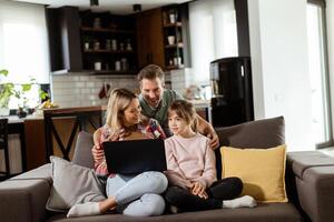 familia unión hora con ordenador portátil en acogedor hogar ajuste foto