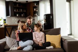 familia unión hora con ordenador portátil en acogedor hogar ajuste foto