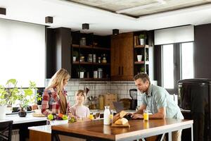 familia chateando y preparando comida alrededor un bullicioso cocina mostrador lleno con Fresco ingredientes y Cocinando utensilios foto