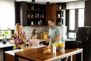 familia chateando y preparando comida alrededor un bullicioso cocina mostrador lleno con Fresco ingredientes y Cocinando utensilios foto