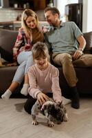 familia unión hora con juguetón francés buldog cachorro en acogedor vivo habitación foto
