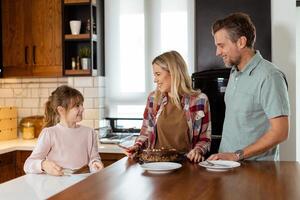 Joyful Family Enjoying Homemade Chocolate Cake in Cozy Kitchen photo