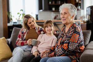 generacional unión, abuela, hija, y nieto compartiendo cuentos en un acogedor tarde foto