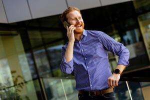 Professional Gentleman Engages in a Serious Conversation on His Smartphone at During a Sunny Afternoon photo