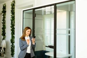 Elegant businesswoman checking her smart watch in a modern office environment photo