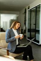 Elegant professional woman engaged in a business call with morning coffee photo