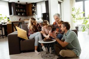 Joyous Family Celebrating Grandmothers Birthday With Cake in a Cozy Living Room photo