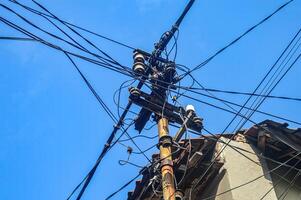 an electric poles with jumbled wires. photo