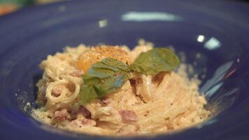 pasta carbonara. espaguetis con tocino, albahaca, parmesano queso y yema de huevo. italiano cocina. video