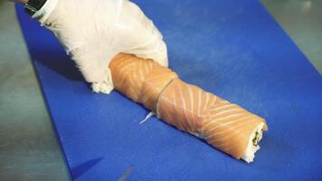 Professional sushi chef cutting rolls. Redfish. Sushi philadelphia video