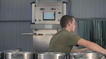 ung manlig bryggare tvättar och steriliserar öl fat använder sig av ett automatisk öl kagge sterilisering maskin video