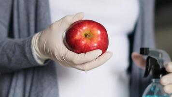 desinfección de productos mundo pandemia. rociar antiséptico. pandemia coronavirus. joven mujer desinfecta productos desde un en línea Tienda utilizando un máscara y rociar antiséptico. de cerca video