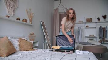 ouvert les frontières, pack choses, content vacances, réservation Hôtel. femme en mettant des choses dans valise pour train sur lit à Accueil video