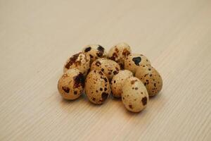 Quail eggs on a wooden background. Close-up, selective focus. photo