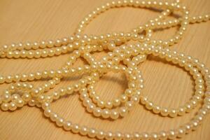 Pearl necklace on wooden background. Close-up. Selective focus. photo