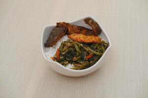 Rice with fried fish and seaweed in a bowl on table photo