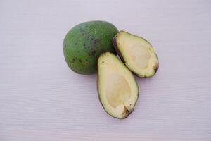 Avocado on the wooden table. Tropical fruit. Close up. photo