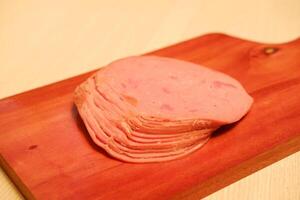 Slices of ham on a cutting board, closeup of photo