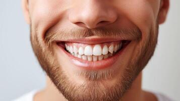 Close up of young man with perfect teeth, isolated on grey background photo