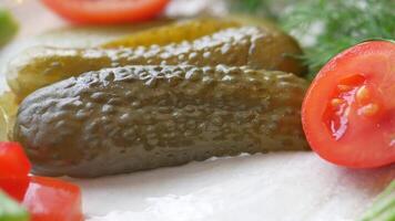 a close up of a pickle on a plate with tomatoes video