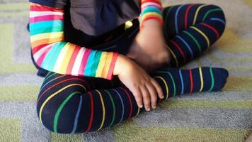 top view of child with Colorful striped socks sitting on carpet video