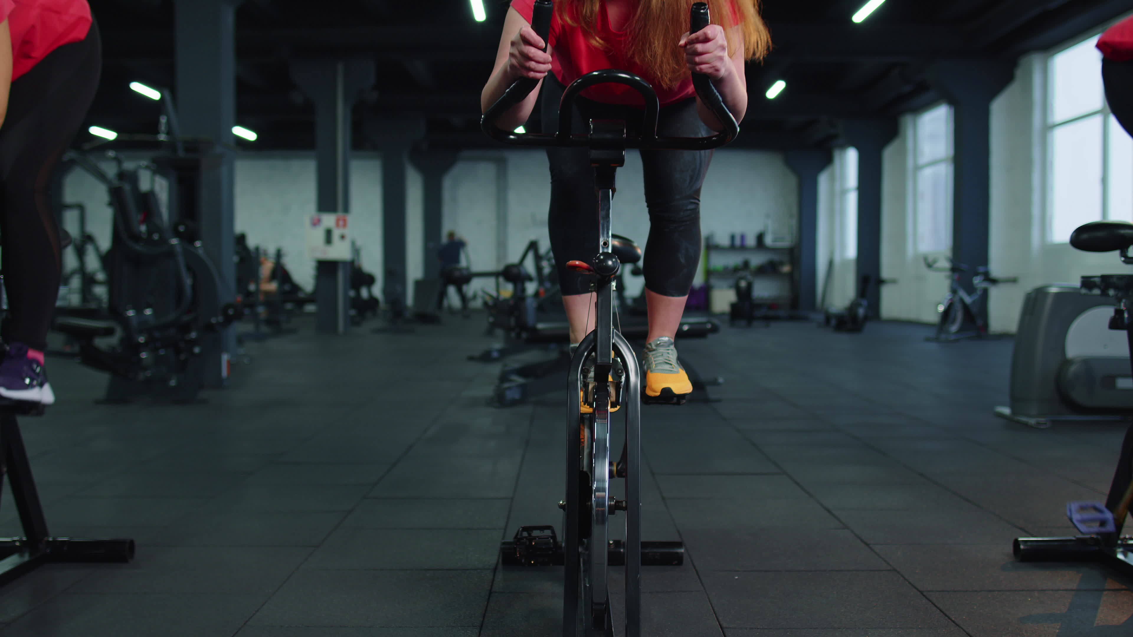 Athletic women group riding on spinning stationary bike training