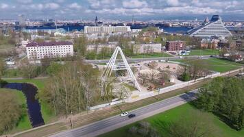 construção trabalho do a Novo ferris roda dentro riga, Letônia. nomeado riga olho ou báltico olho. ensolarado dia sobre riga, aéreo visualizar. video