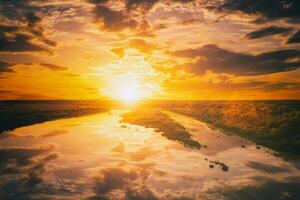 Sunrise or sunset on a lake or river with cloudy sky reflection in the water in summertime. Aesthetics of vintage film. photo