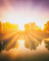 amanecer en un lago o río con un cielo reflejado en el agua, abedul arboles en el apuntalar y el rayos de sol rotura mediante ellos y niebla en otoño. estética de Clásico película. foto