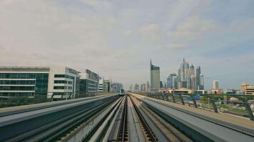 UAE, Dubai - United Arab Emirates 01 April 2024 Dubai Metro Rail with City Skyline, Perspective view from Dubai metro rail leading to the urban skyline under hazy sky. video