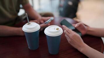 Close-up of a woman and a man exchanging ideas with a friend on a smartphone using a modern mobile app. video