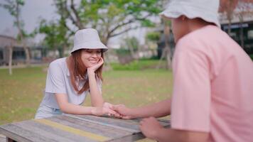 couple séance sur une table sur le balcon, collage, confiant ou justificatif aimer, souriant, content ou parlant avec une femme et homme dans une relaxant printemps Pause partir. video