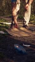 diverso grupo de voluntarios cosecha arriba basura y el plastico a reciclar, trabajando juntos a preservar y restaurar naturaleza. activistas combatiendo ilegal dumping, coleccionar basura en bolsas. cámara b. video