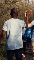 Cheerful people doing high five gesture with each other after finishing garbage and plastic waste cleanup, congratulating activists. Volunteer leader expressing praise for a job well done. Camera B. video