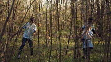 groep van redders in leven vrijwilligers zoeken voor een missend persoon, roeping hun naam in de bossen en gaan door de bomen naar bijhouden stappen. zoeken ploeg redders op zoek voor een verloren slachtoffer. camera b. video