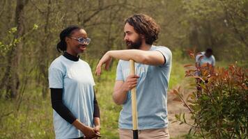 Portrait of diverse activists team tidying natural environment by working on reforestation and engaging in litter cleanup, recycle garbage. Volunteers protecting wildlife and ecosystems. Camera A. video