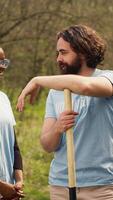 retrato de diverso activistas equipo ordenar natural ambiente por trabajando en repoblación forestal y atractivo en camada limpiar, reciclar basura. voluntarios proteger fauna silvestre y ecosistemas cámara una. video