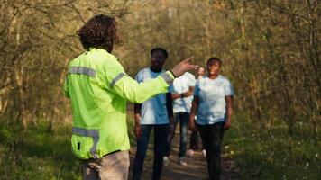 capitaine de le chercher fête dirige le sien équipe par le les bois à collecte détails pendant en cours chasser pour une disparu personne. voix appel en dehors pour un personnes nom, civil disparu dans le sauvage. caméra un. video