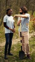 portrait de diverse militants équipe ranger Naturel environnement par travail sur reboisement et engageant dans litière nettoyer, recycler ordures. bénévoles protéger faune et écosystèmes. caméra b. video