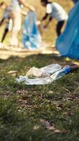 Citizens reducing pollution and illegal disposal by tidying the environment and recycling plastic with the right instruments. Volunteers clearing garbage from the forest. Close up. Camera B. video