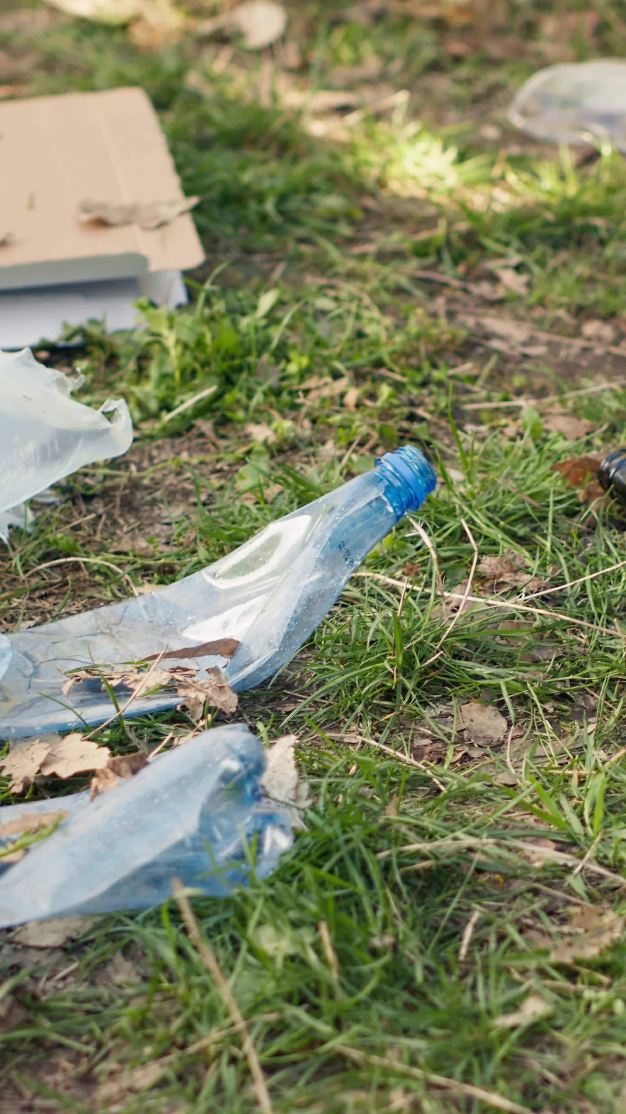 Volunteer using tongs tool to collect trash and plastic waste from the