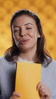 Vertical Portrait of upbeat content creator reviewing newly published books, presenting synopsis to audience. Media star sponsored by publisher to show new novel releases to subscribers, studio background video