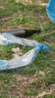 People supporting cleanup of the natural environment by grabbing recyclables and trash objects from the woods, collecting in a garbage bag. Using utensils to pick up rubbish. Close up. Camera A. video